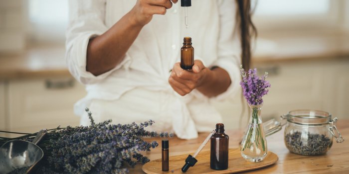 young woman applying natural organic essential oil on hair and skin home spa and beauty rituals skin care