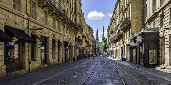 a pic of a street in bordeaux france with the cathedral at the end
