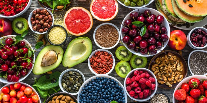 selection of healthy food superfoods, various fruits and assorted berries, nuts and seeds