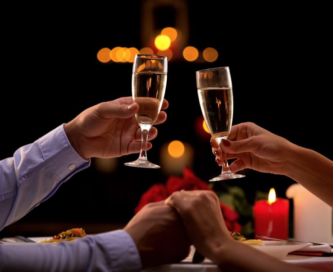 nice couple holding hands, drinking champagne during romantic date, anniversary