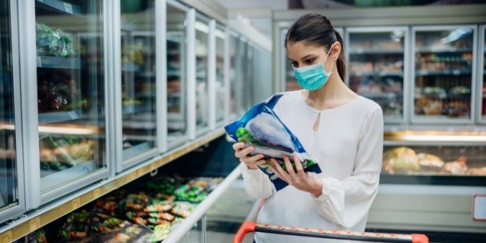 woman with hygienic mask shopping for suppliescpandemic quarantine preparationhoosing nonperishable food essentials from ...